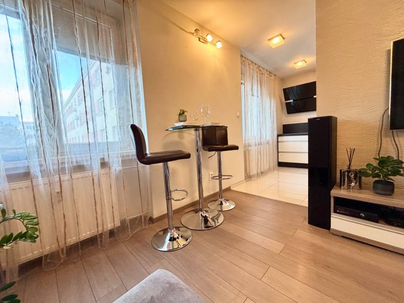 A kétszobás lakás belső tere fa dekor padlóval, bárszékekkel és dekorációkkal.