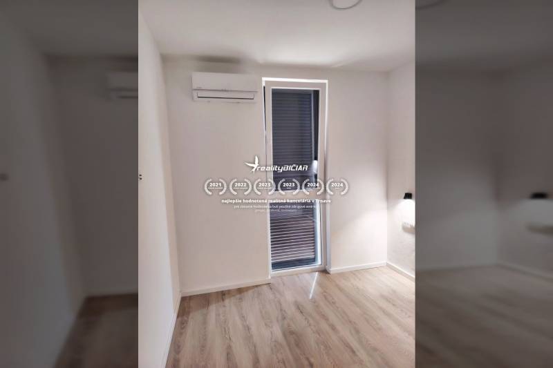 Szoba családi házban ablakkal, légkondicionálóval és fa dekorációjú padlóval.