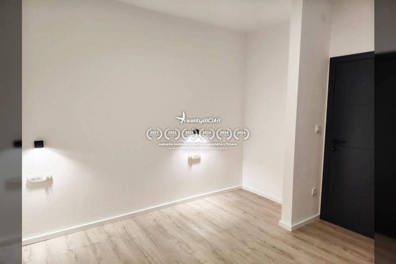 Családi ház fehér falakkal, sötét ajtókkal és fa dekorú padlóval.