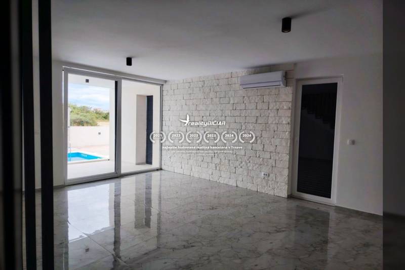 Nappali márványpadlóval és tolóajtókkal egy családi házban.