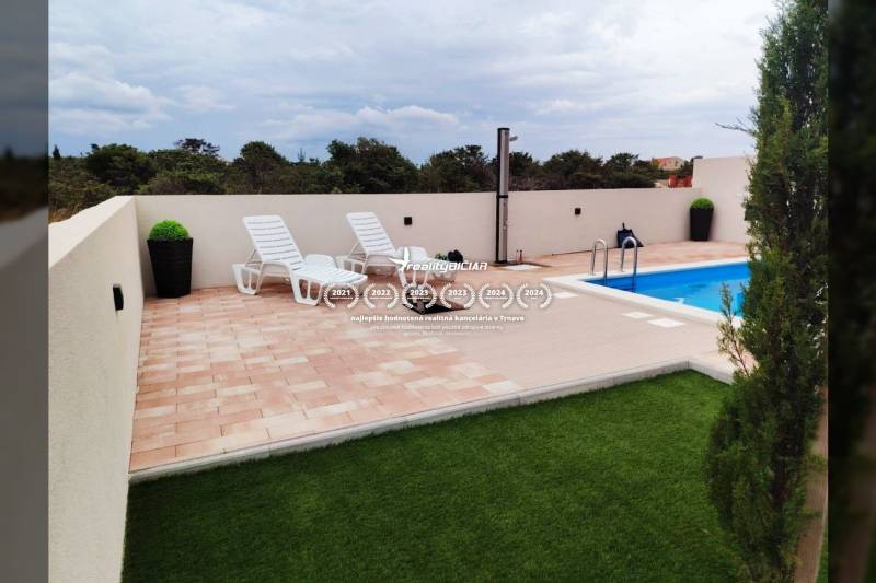 Terasz napozóágyakkal és medencével egy családi házban a Mulo utcában, Vrsiben.