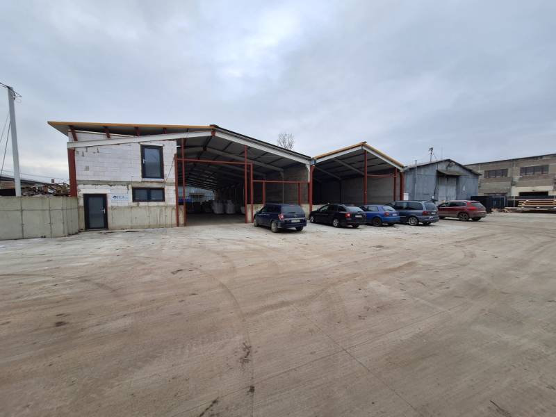 Raktár- és csarnokterület a Strojnícka utcában, Eperjesen, parkolóval és autókkal.