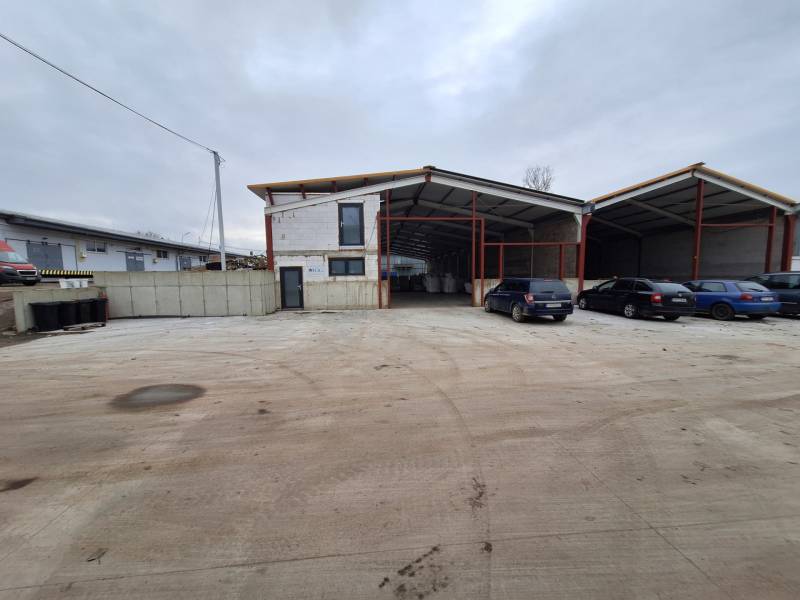 Ipari épület a Strojnícka utcában, Eperjesen, parkolóhelyekkel és autókkal.