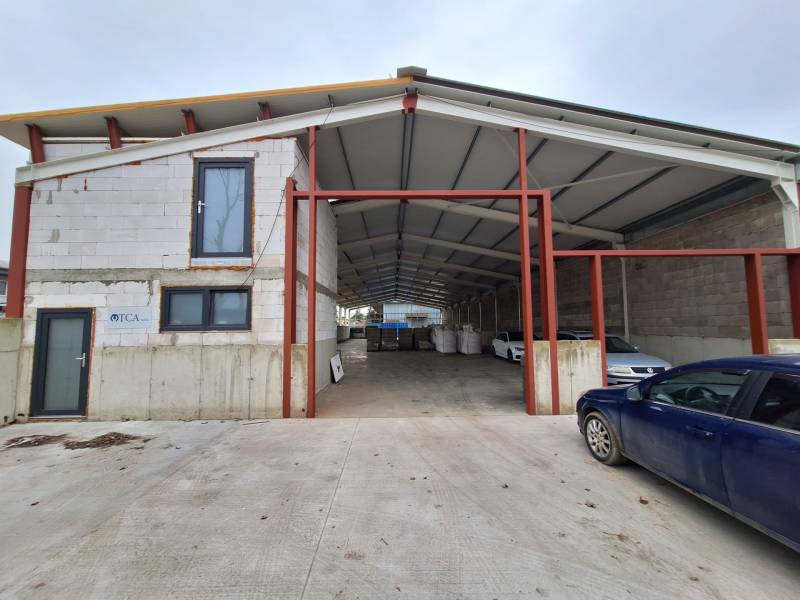 Raktárak és csarnokok a Strojnícka utcában, Eperjesen, egy autóval az épület előtt.