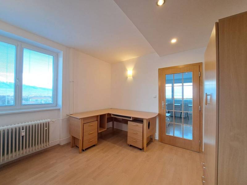 Dolgozószoba egy négy szobás lakásban, fa mintázatú padlóval és íróasztallal.