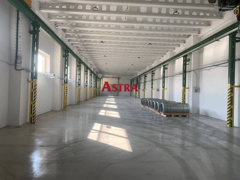 Raktár és csarnok belső tere acéltekercsekkel betonpadlón.