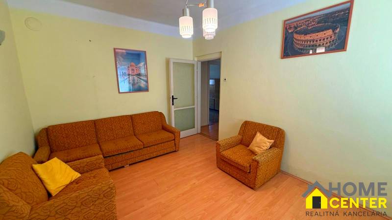 Nappali egy családi házban narancssárga bútorokkal és fa dekorációjú padlóval.