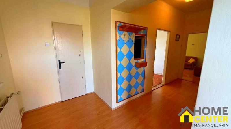 Folyosó a családi házban színes fallal és fa dekorációjú padlóval.