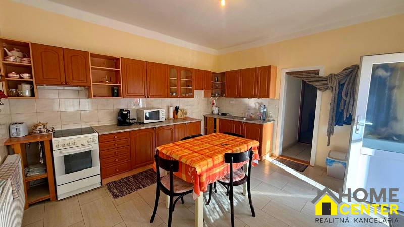 Konyha családi házban fa dekorációval és étkezőasztallal.