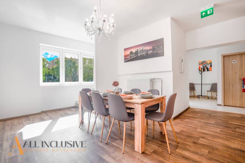 Ebédlő csillárral és fa dekorációjú padlóval az épületben.