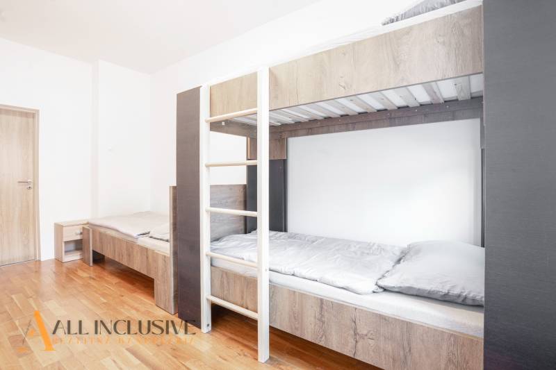 Emeletes ággyal és fa dekorációjú padlóval rendelkező belső tér egy épületben.