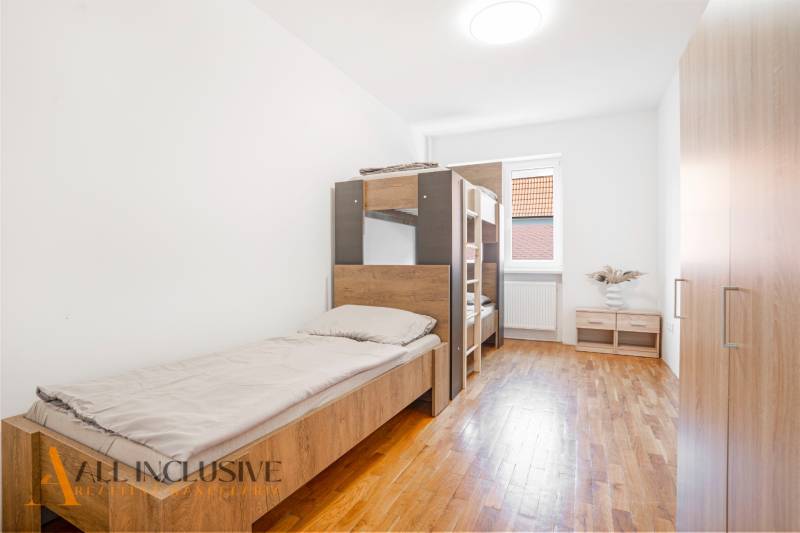 Hálószoba belső tér egy épületben, ágyakkal és fa dekorációjú padlóval.