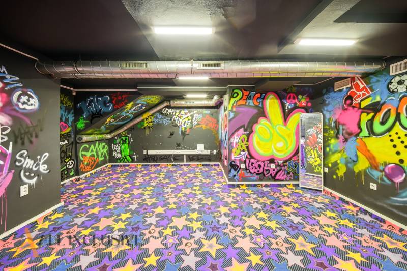 Az épület belseje graffiti-vel a falakon és színes csillagos szőnyeggel.