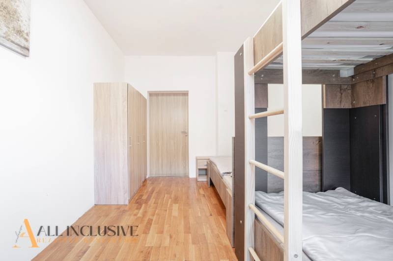 Emeletes ággyal, szekrényekkel és fa dekorációjú padlóval berendezett belső tér.