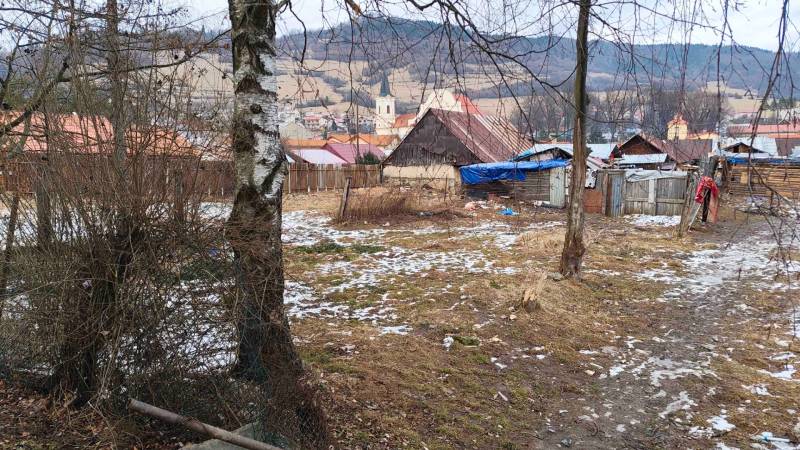 Havas kertek Nálepkovóban, faházakkal és kilátással a dombokra és a templomra.