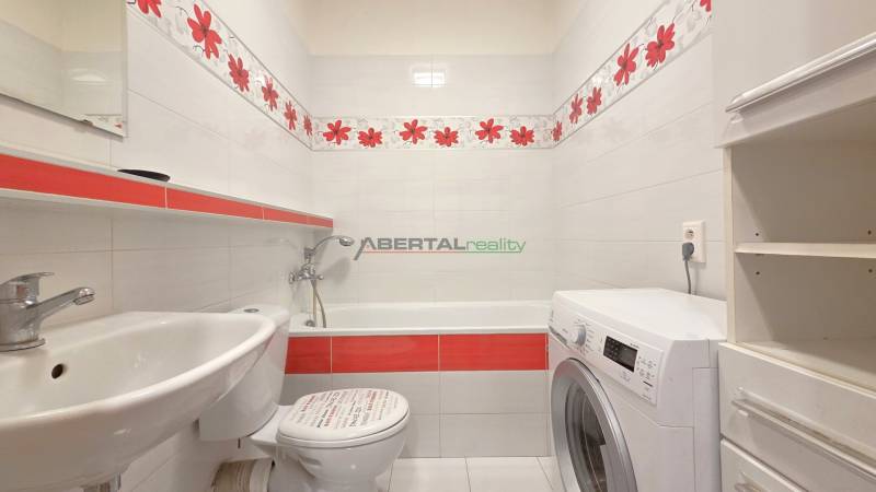 Fürdőszoba káddal, mosdóval és mosógéppel egy kétszobás lakásban.