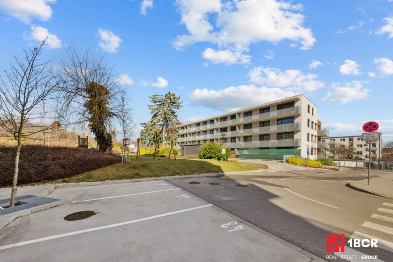 A Skalická úti lakóház Pozsony-Újvárosban. Az előtérben parkolóhelyek találhatók.