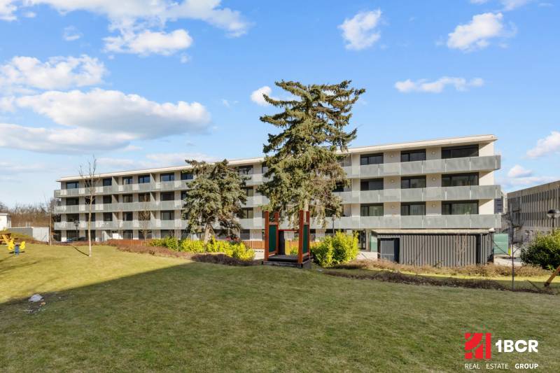 Négyemeletes lakóház, gyep veszi körül, Pozsony - Újváros, Skalická út.