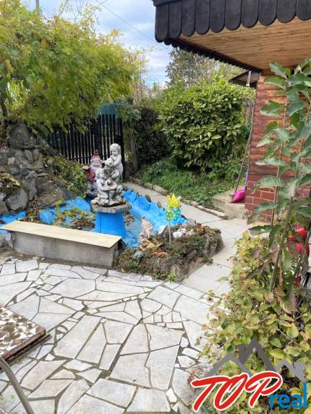 A kassai Vyšné Opátske városrészben található hétvégi ház kertje téglaházzal és szoborral.