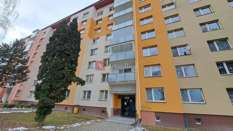 Egy hét emeletes lakóház a Za dráhou utcában, Rózsahegyen, fákkal körülvéve.