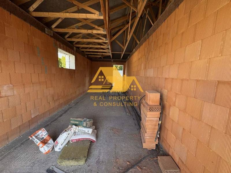 Családi ház építése Nové Zámky utcájában téglafalakkal és gerendás mennyezettel.