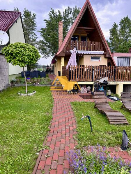 Házikó piros tetővel, terasszal és pihenőkerttel Érsekújváron.