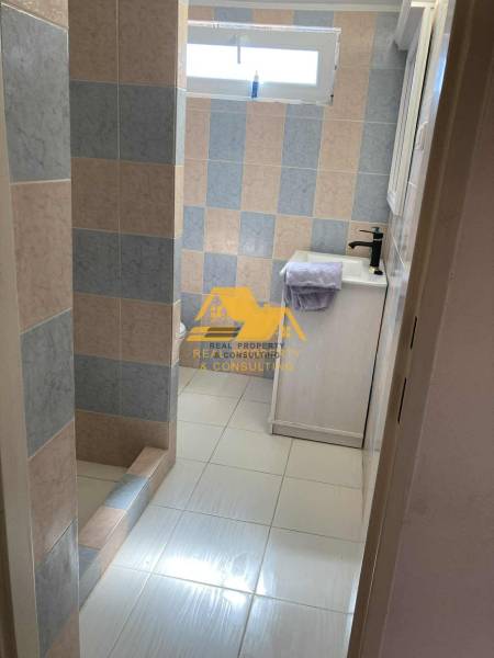 Fürdőszoba a házikóban színes csempékkel és zuhanyzóval, zuhanyfallal.