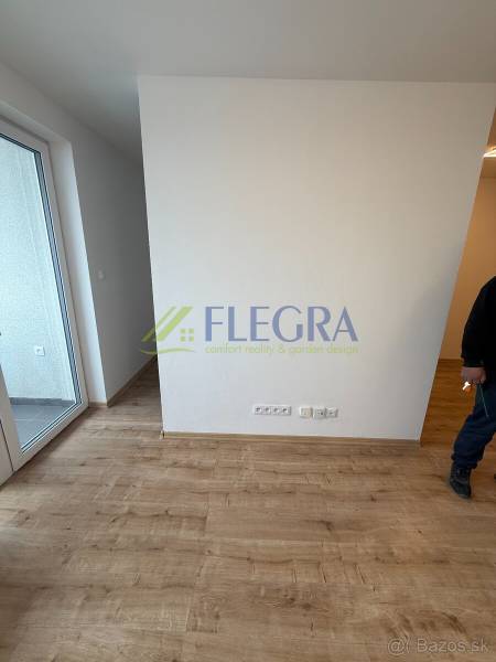 Egyszobás lakás belső tere fa dekor padlóval és erkéllyel.