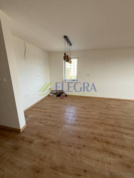 Két hálószobás lakás szobája fa dekor padlóval és függő lámpákkal.