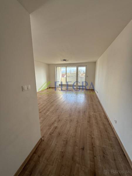 Világos nappali fa mintázatú padlóval egy kétszobás lakásban.