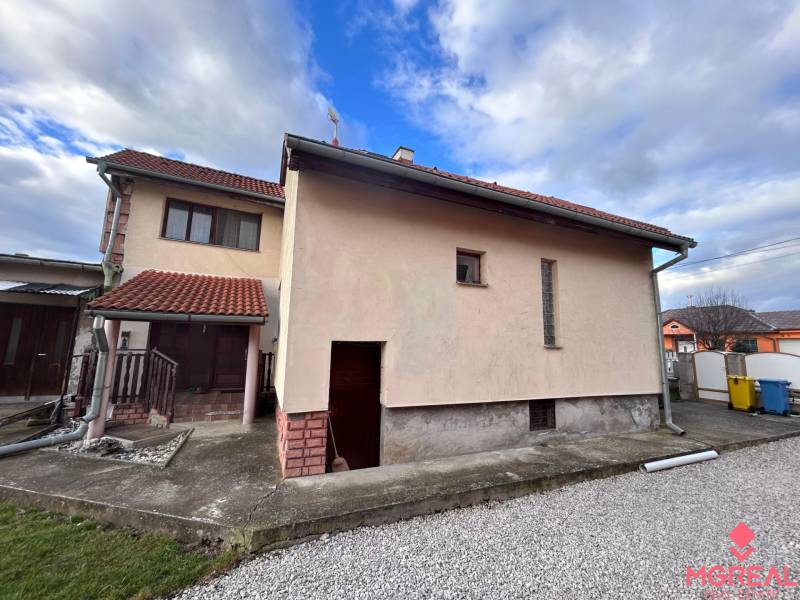 Családi ház Zbehyben ferde tetővel és garázs melletti járdával.