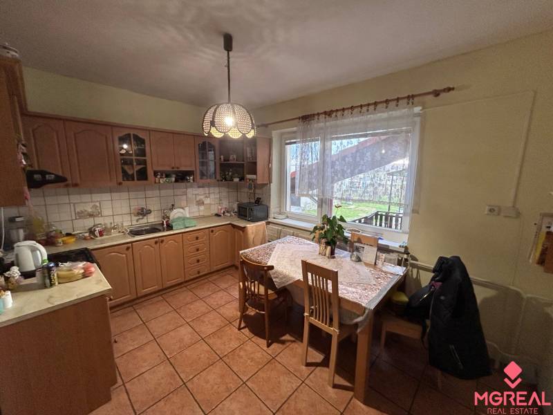 Konyha családi házban fa dekorral és étkezőasztallal.