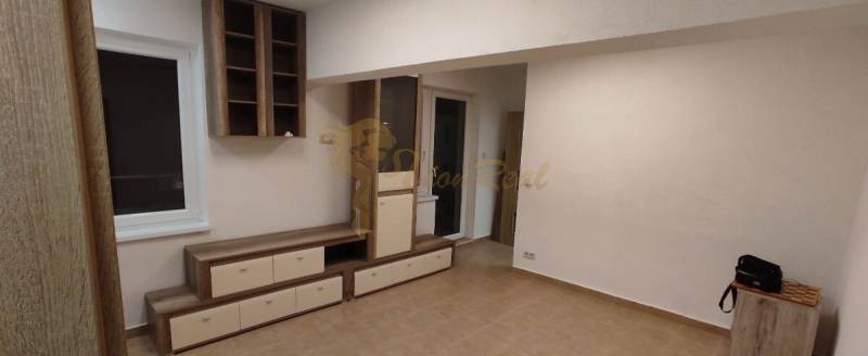 Egy szobás lakás nappalija fa dekorációjú bútorokkal és padlóval.