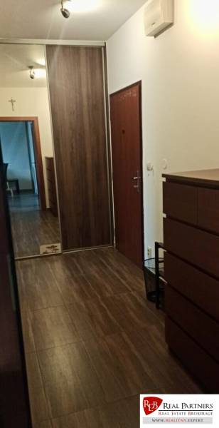 Folyosó egy kétszobás lakásban, fa dekoros padlóval, beépített szekrénnyel és tükrös elemmel.