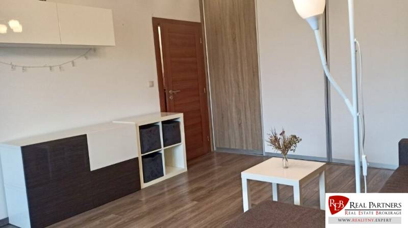 Nappali egy kétszobás lakásban, fa dekoros padlóval és modern bútorokkal.