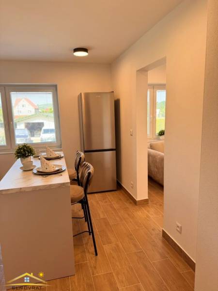 Konyha egy 2 szobás lakásban bárral, fa dekorációjú padlóval és hűtőszekrénnyel.