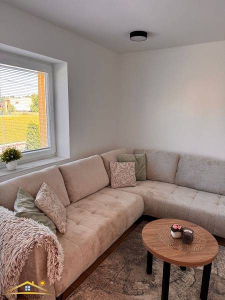 Kényelmes kanapé és dohányzóasztal egy kétszobás lakásban, kilátással kifelé.