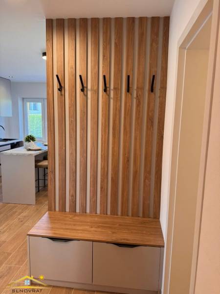 Előszoba egy kétszobás lakásban, lamellás fallal és tárolóhelyes komóddal.