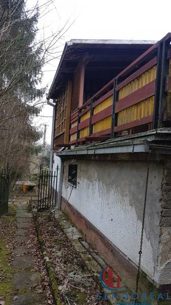 Chata na Výtockej ulici v Moravanoch nad Váhom s dreveným balkónom obklopená prírodou.