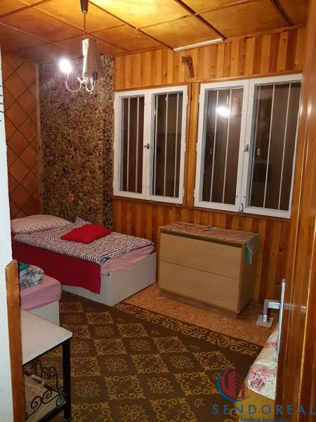 Izba v chate s posteľou, drevenými stenami