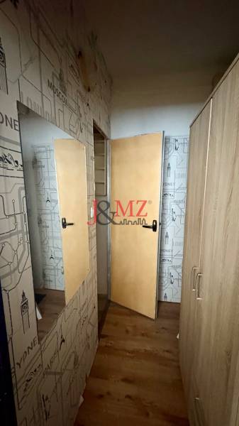 Garzonlakás utazási témájú falakkal és fa dekorációjú padlóval.