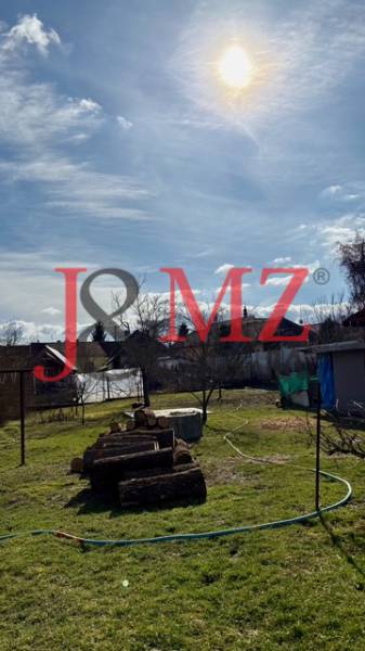 Kert nyírt gyep és faanyag a családi ház területén Mýtné Ludanyban.