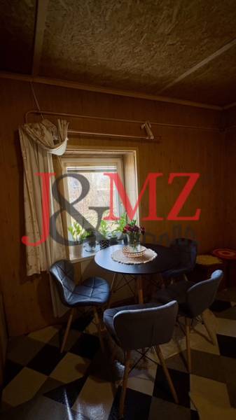 Étkező sarok családi házban mintás padlóval és székekkel a kerek asztal körül.