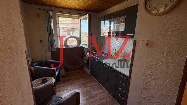 Konyha fa hatású padlóval és sötét szekrényekkel egy családi házban.