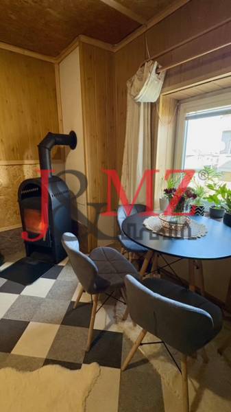 Kandalló a családi ház nappalijában kerek asztallal és két székkel.