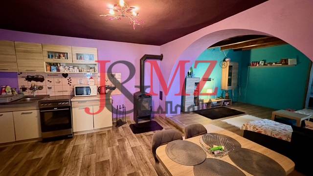 Konyha és nappali családi házban fa dekoros padlóval és kandallóval.