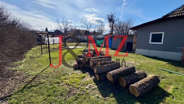 A Mýtné Ludan-i családi ház udvara farakással és kerítéssel.