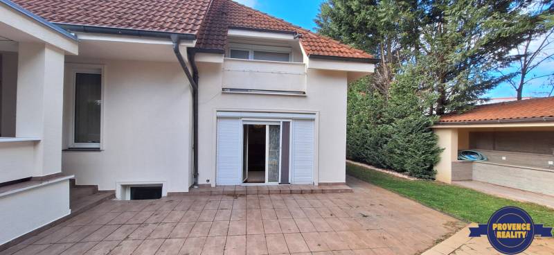 Családi ház Komáromban terasszal, kerttel és fehér spalettákkal.