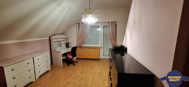 Szoba fa dekorációjú padlóval, bútorokkal és csillárral egy családi házban.