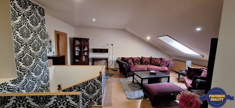 Nappali kanapékkal és mintás falakkal, fa dekorációjú padlóval.